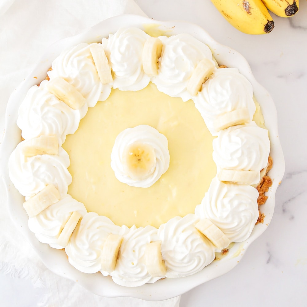Banana Cream Pie recipe garnished with whipped cream and bananas.