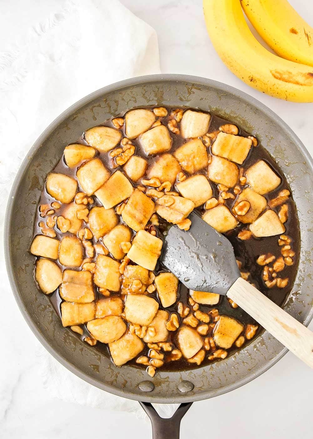 Cooking bananas in a caramel sauce in a pan.