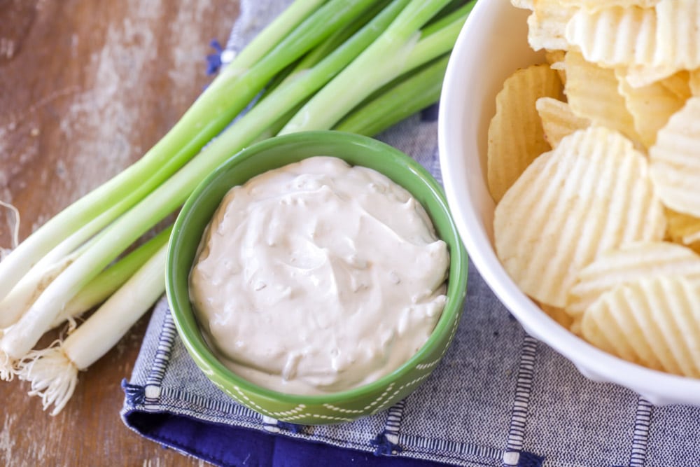 Party appetizers - bowl of french onion dip served with potato chips.