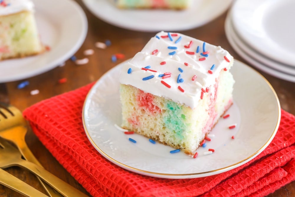 Patriotic poke cake slice on a white plate.