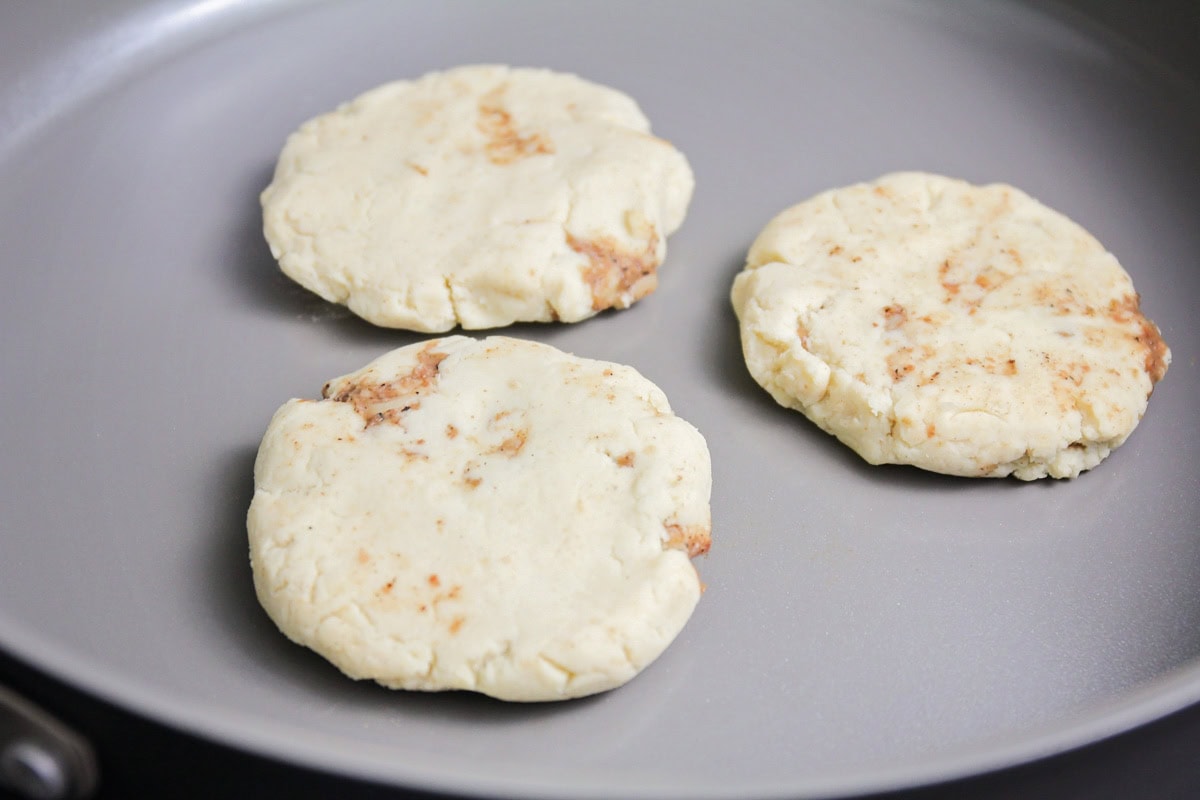 Pupusas being fried on pan.