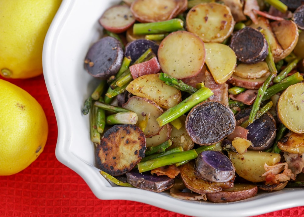 Vegetable side dishes - asparagus and potatoes medley piled in a white bowl.
