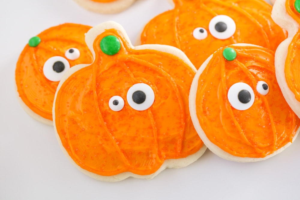 Halloween desserts - pumpkin shaped Halloween sugar cookies covered in orange frosting.
