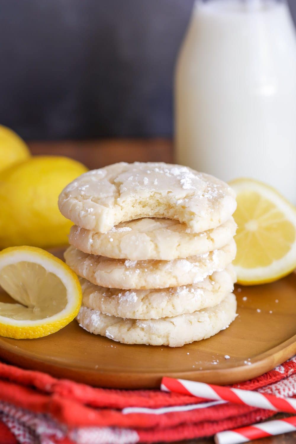 Lemon crinkle cookie recipe stacked on a wooden plate.
