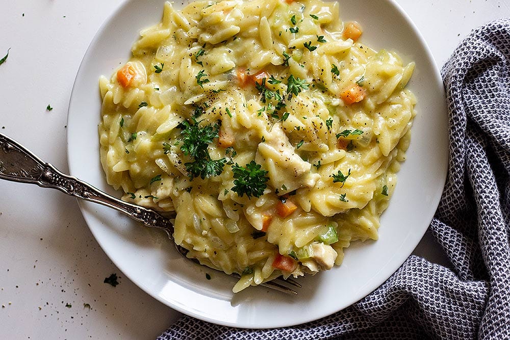 Chicken orzo on a white plate with a fork