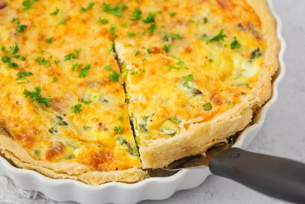 Cutting a slice out of asparagus quiche