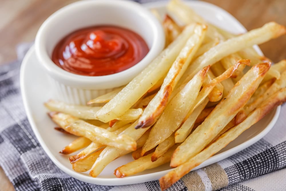 Healthy Appetizers - Baked French Fries on a white plate with a side of ketchup in a white ramekin. 