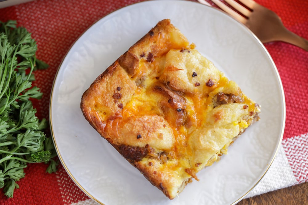 A slice of Christmas breakfast casserole on a white plate