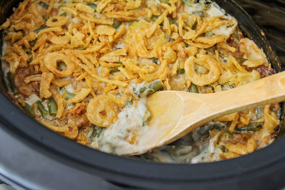 Thanksgiving side dishes - crock pot green bean casserole topped with crispy onions.