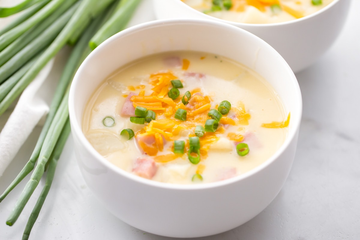Ham and potato soup with cheese and green onions on top