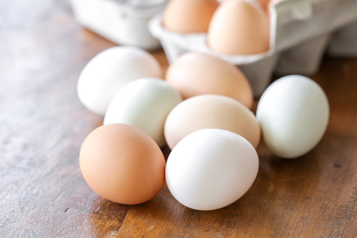 Eggs piled on a kitchen table.