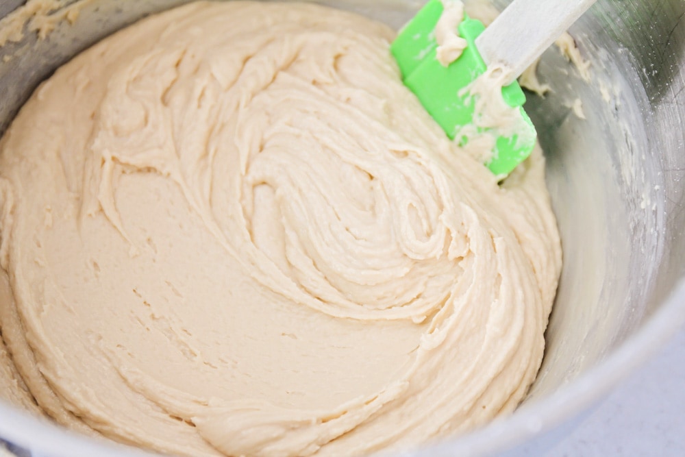 Caramel cake frosting in a mixing bowl with a spatula