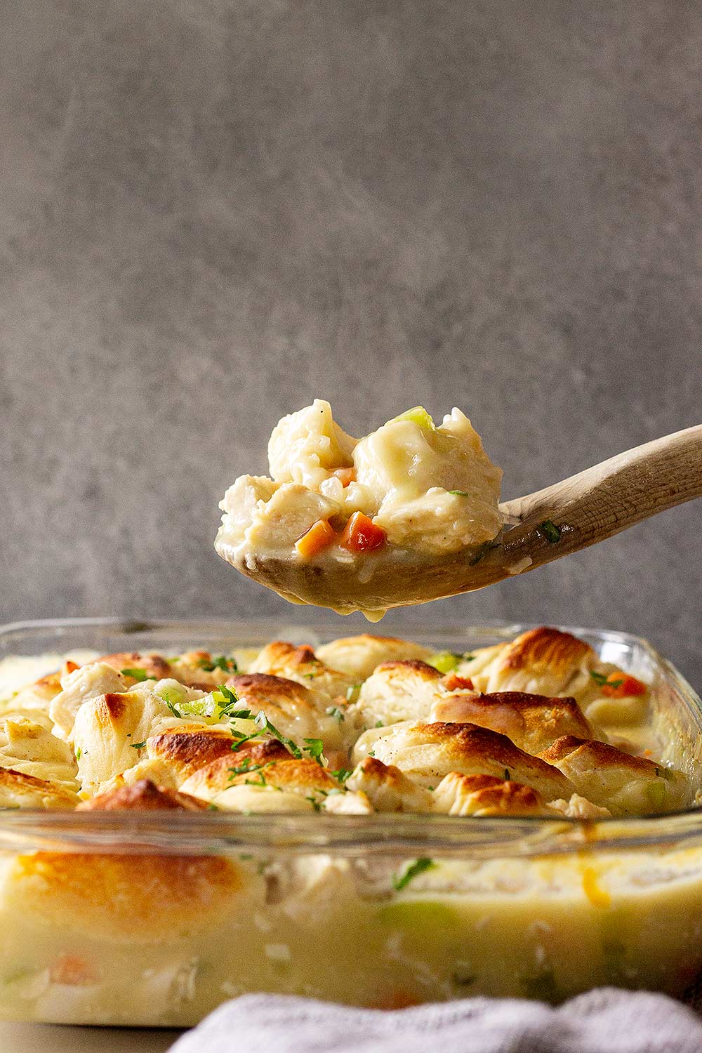 Chicken and dumpling casserole recipe scooped on wooden spoon