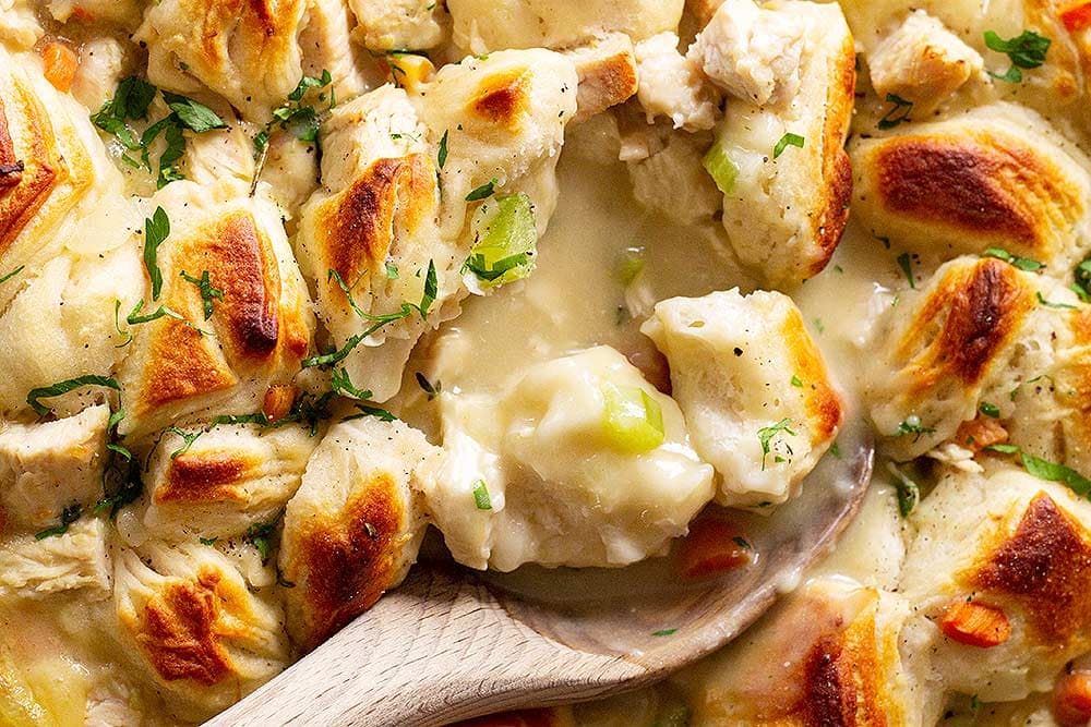 Chicken and dumpling casserole with a serving spoon