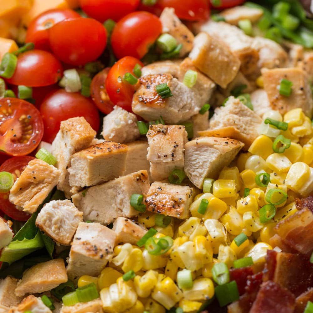 Close up of chopped chicken and veggies on a salad.