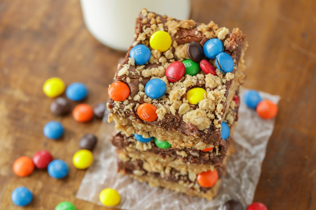 Monster cookie bars cut and stacked on wax paper.