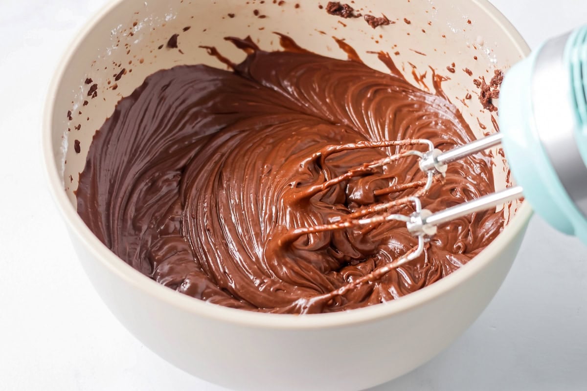Mixing chocolate frosting together in mixing bowl.