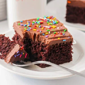 Sour cream chocolate cake recipe on white plate with fork.