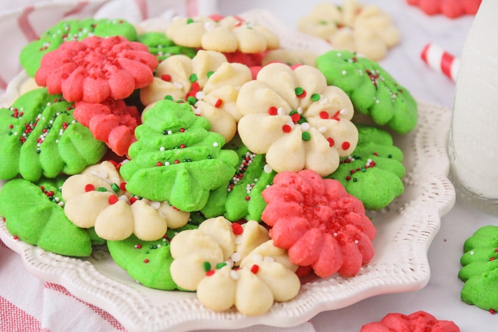 Christmas colored spritz cookies piled onto a plate