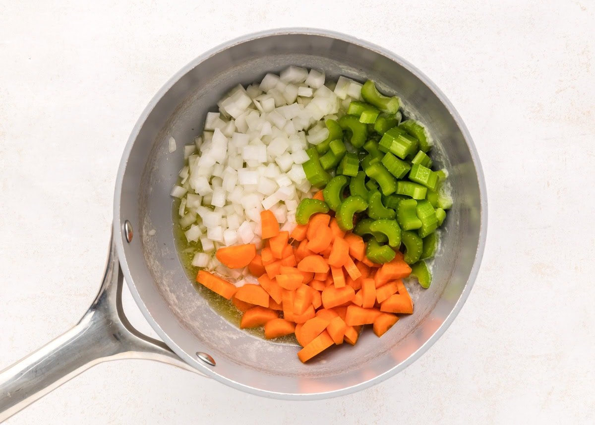Veggies being sauteed in pot.
