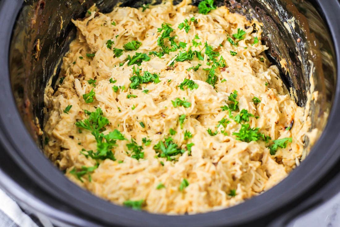 Crack chicken in a crock pot, garnished with parsley.