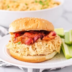 Crack chicken served on a bun topped with bacon.