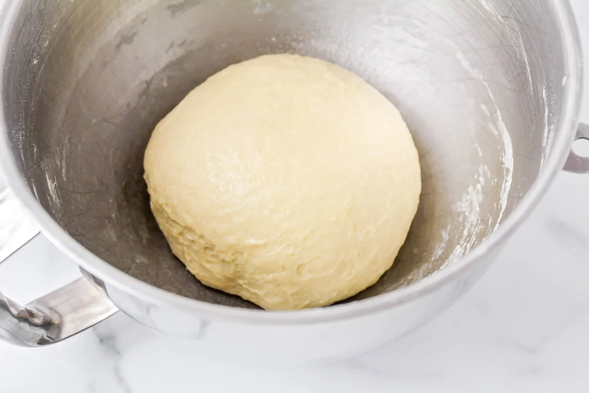 Crescent roll dough in ball in mixing bowl.