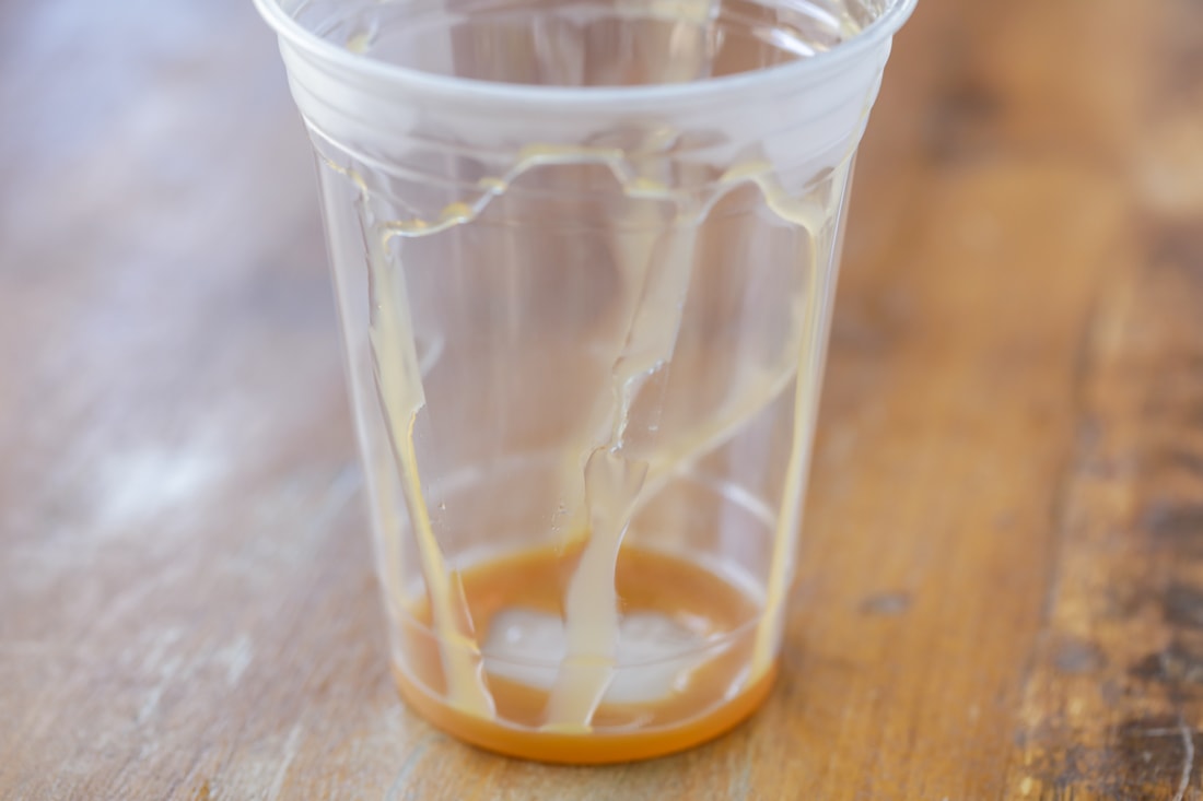 Plastic cup drizzled with caramel syrup