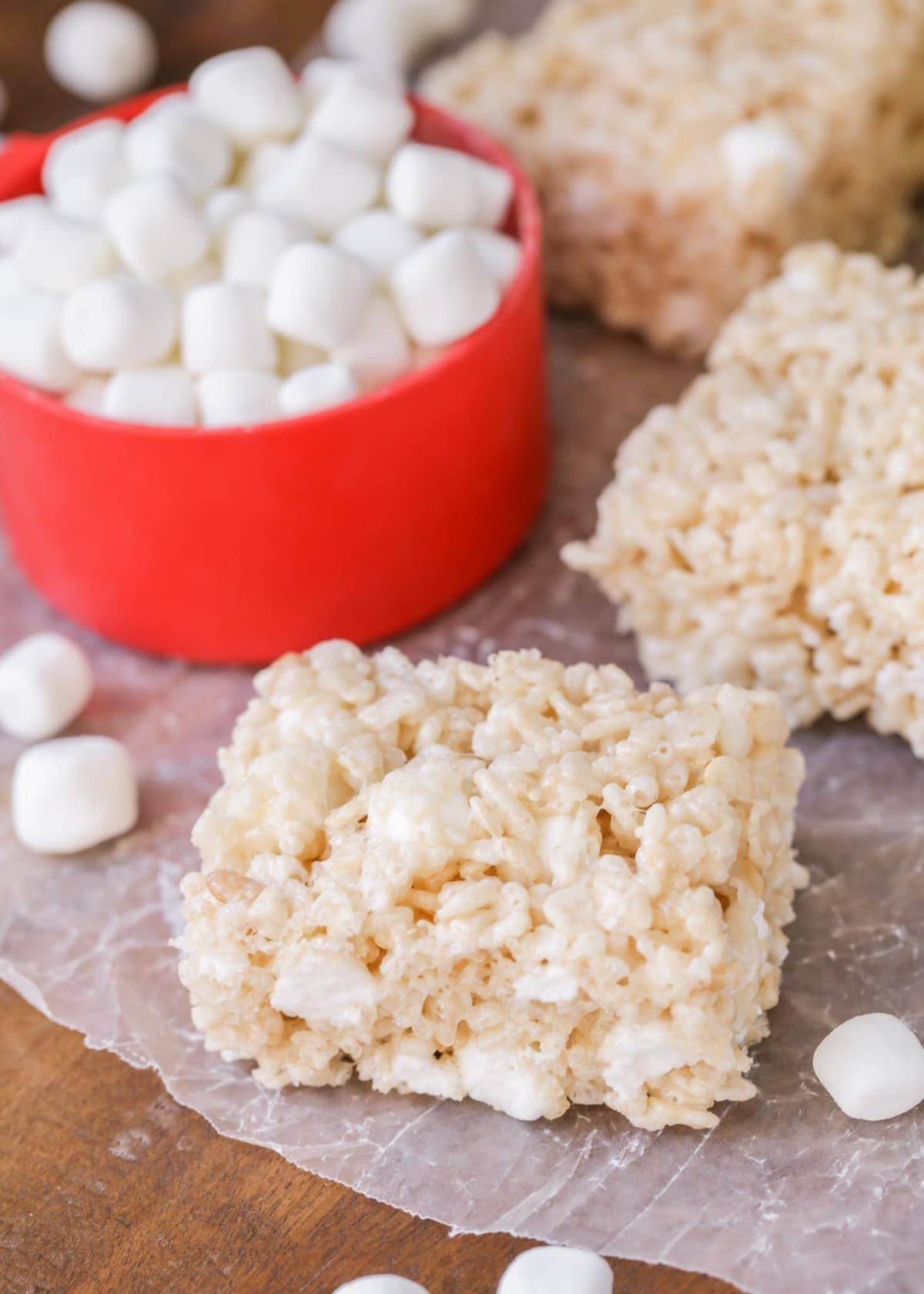 Rice Krispie treats squares served with a bowl of marshmallows.