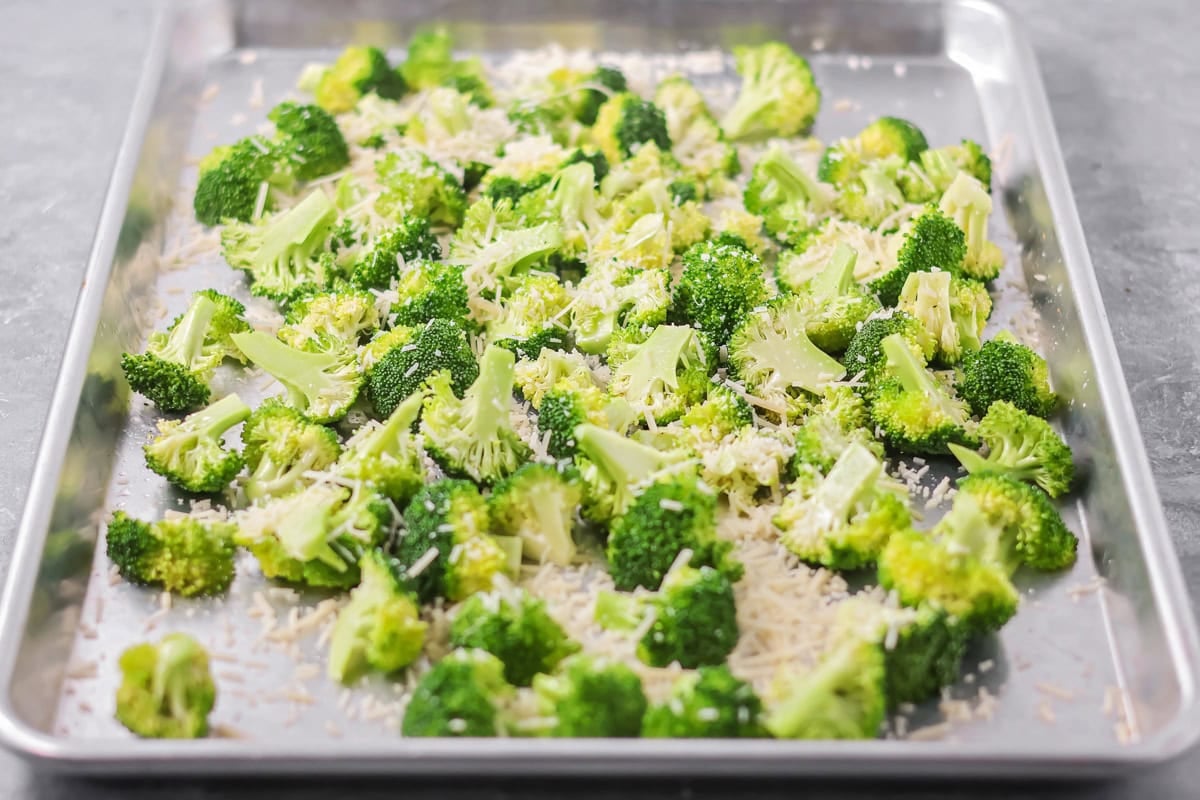 Broccoli spread out on baking sheet.