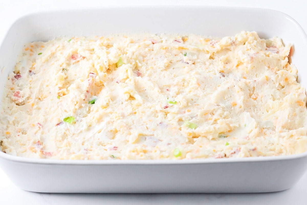Twice baked potato casserole filling spread in a baking dish.