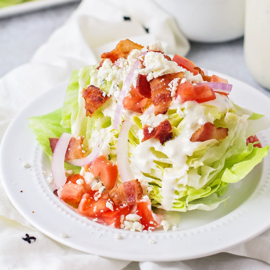 Christmas dinner ideas - wedge salad topped with bacon and dressing.