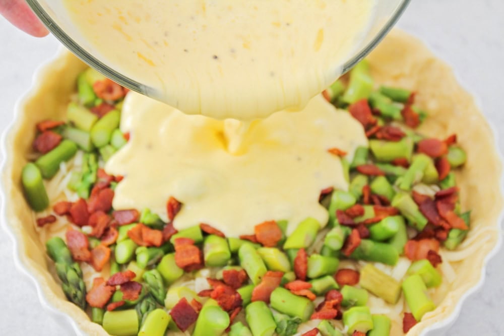 Asparagus quiche ingredients in baking dish.