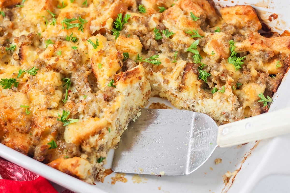 Removing a slice of Christmas breakfast casserole from the baking dish.