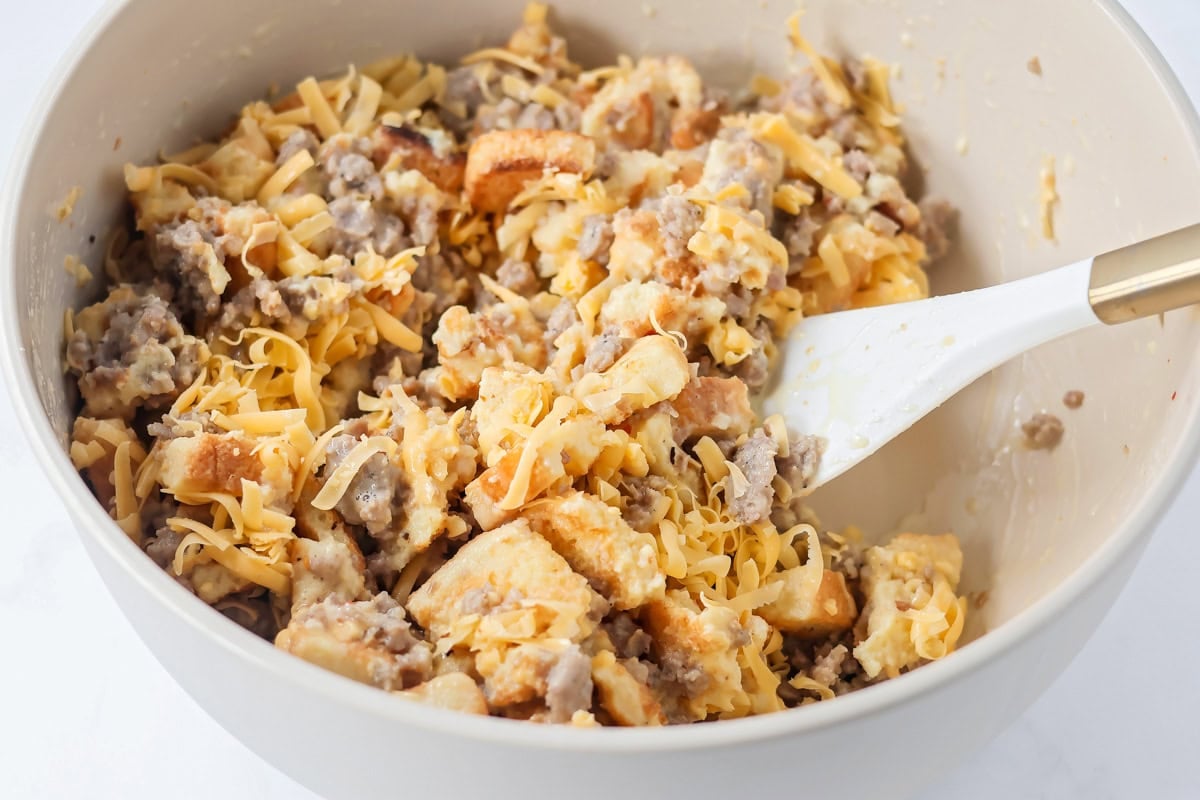 A bowl filled with Christmas breakfast casserole ready to be baked.