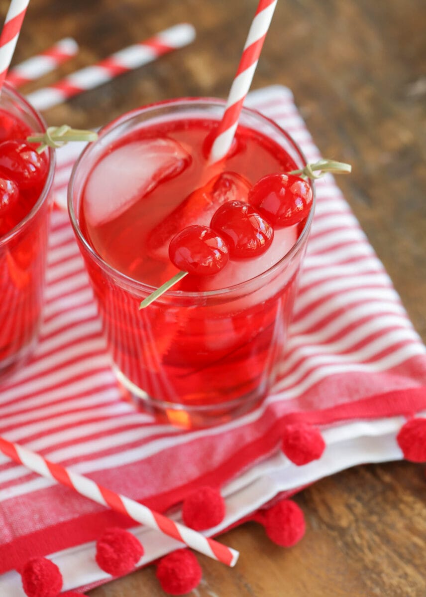 Shirley temple drink in a glass cup topped with cherries