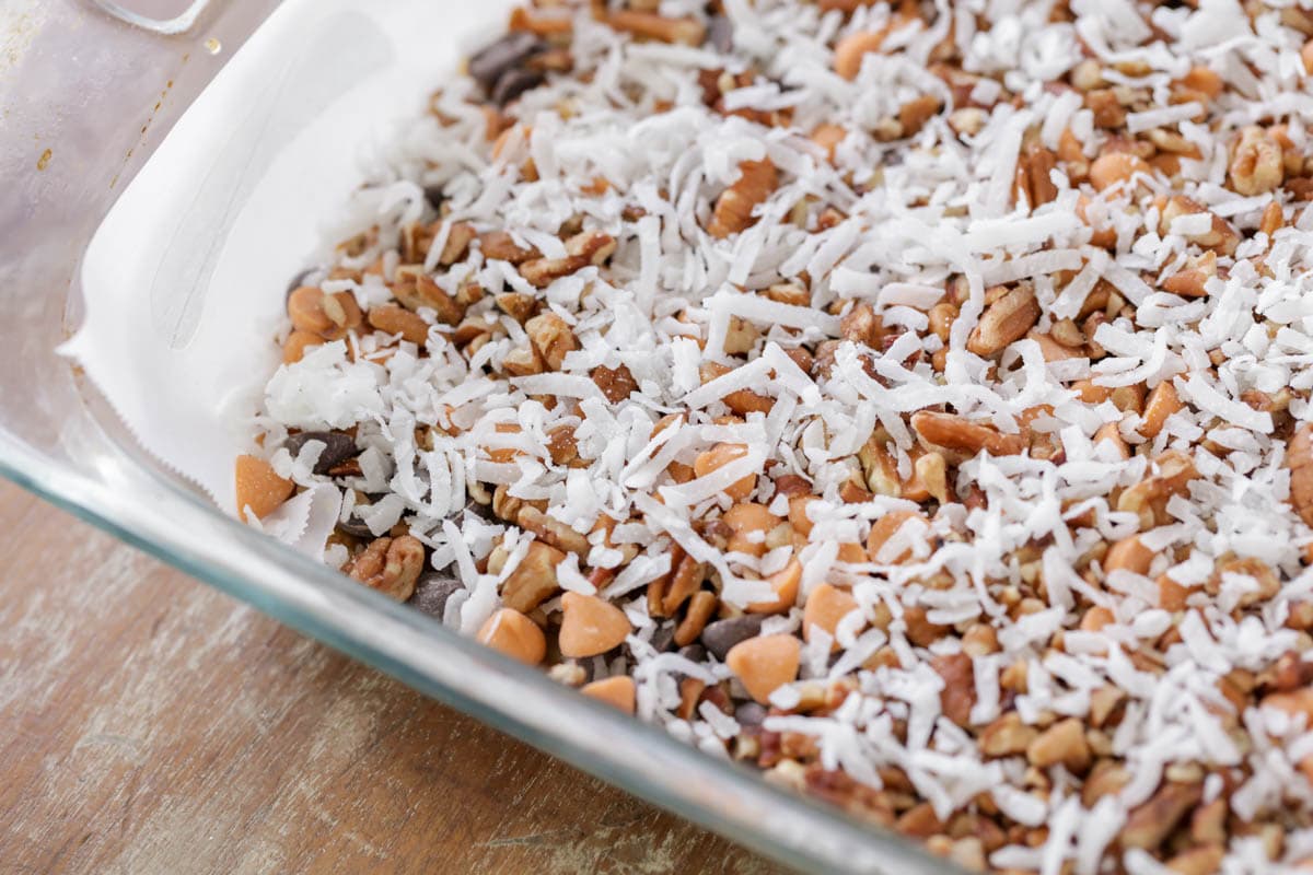 Sprinkling coconut on baking chip and nut layer.