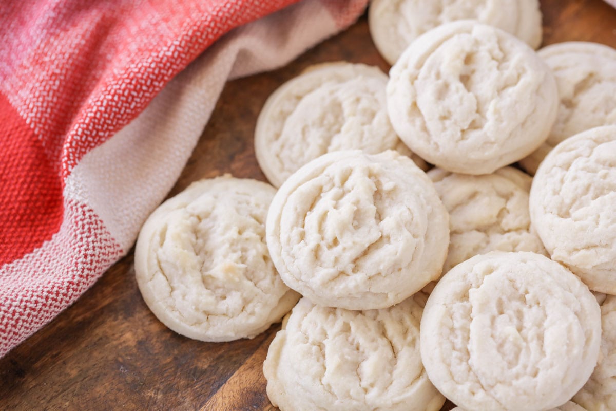 Amish sugar cookies piled on a wooden board