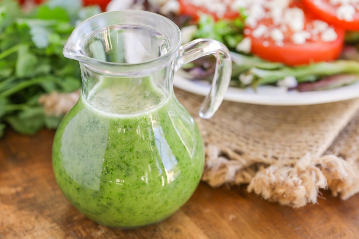 Cilantro lime vinaigrette in a clear salad dressing carafe.