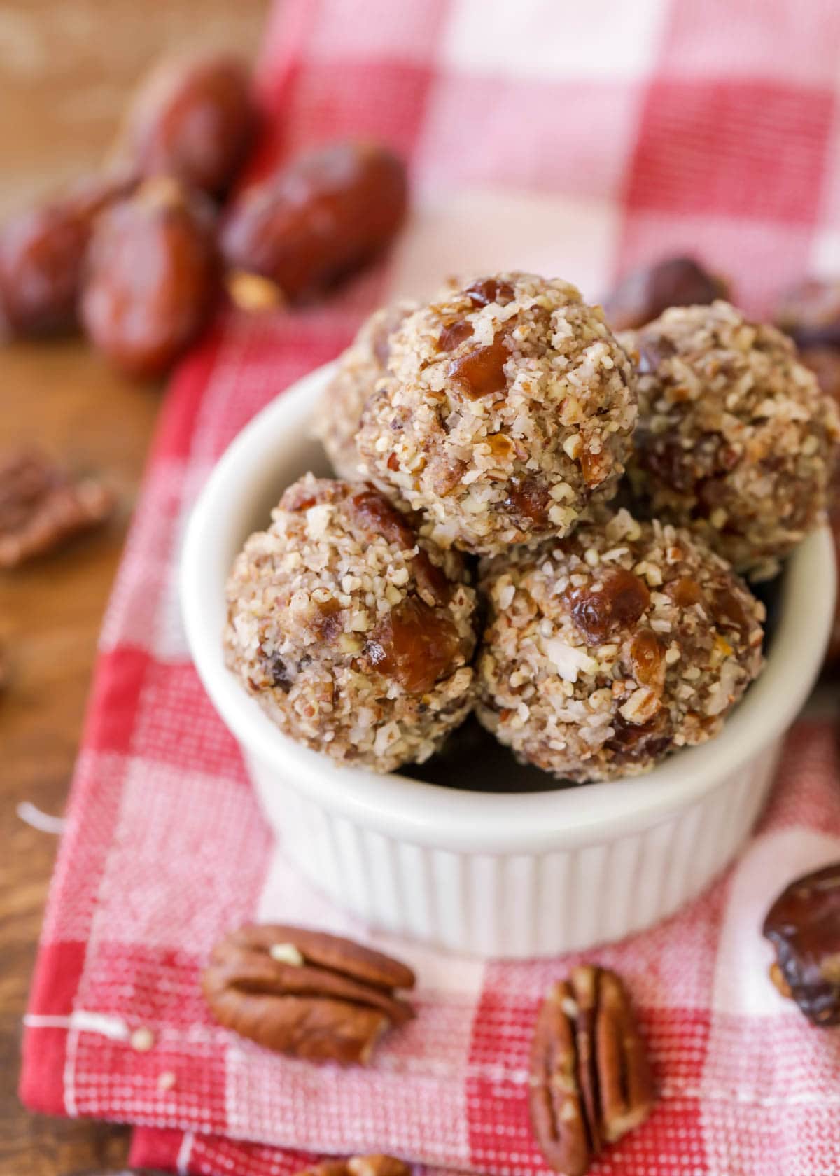 Date balls with coconut and pecans in a small serving dish