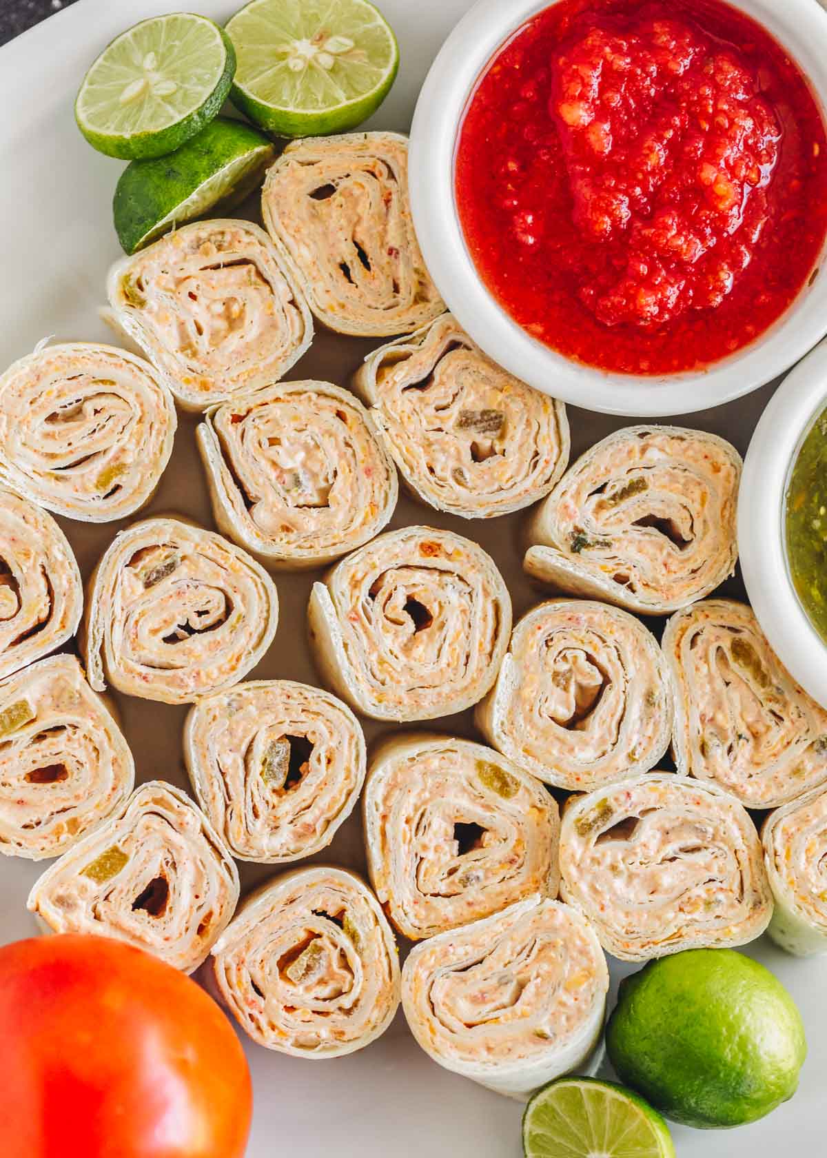 Fiesta pinwheel appetizers on a platter with salsa