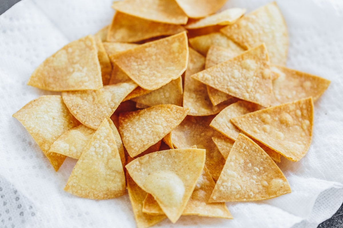 Homemade corn tortilla chips draining on a papertowel