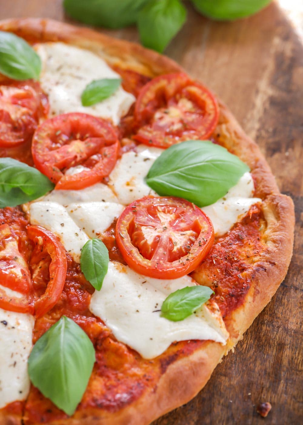 Closeup of margherita pizza recipe topped with basil.