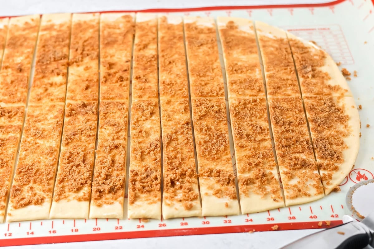 Cutting mini cinnamon rolls strips.