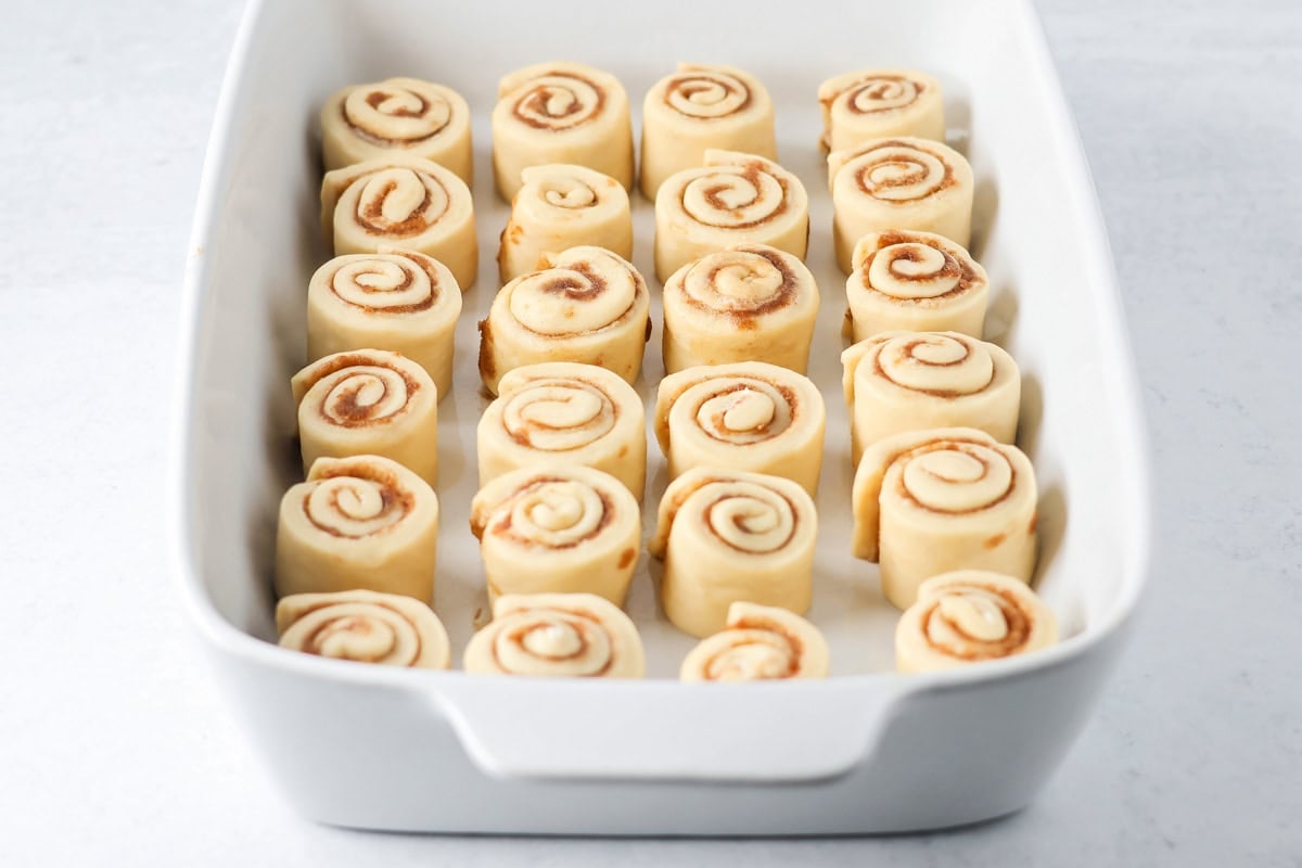Rolled mini cinnamon rolls in a baking dish.