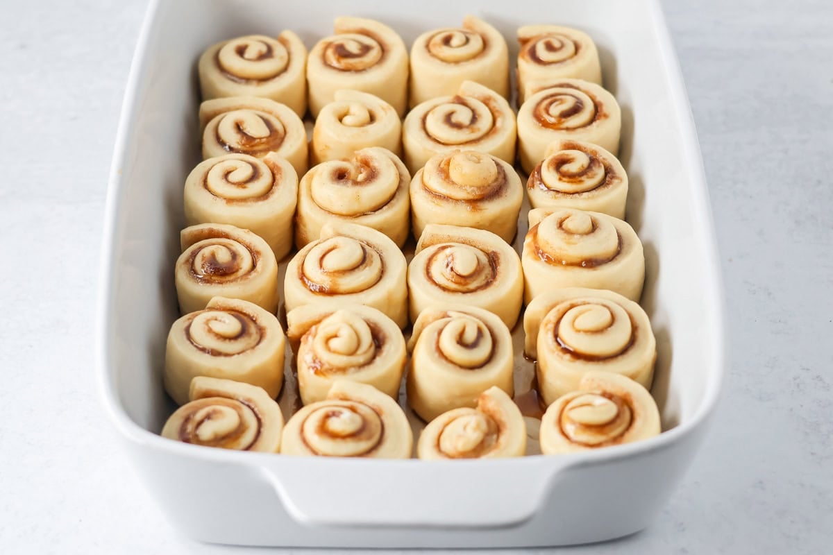 Mini cinnamon rolls in a baking dish ready to be baked.