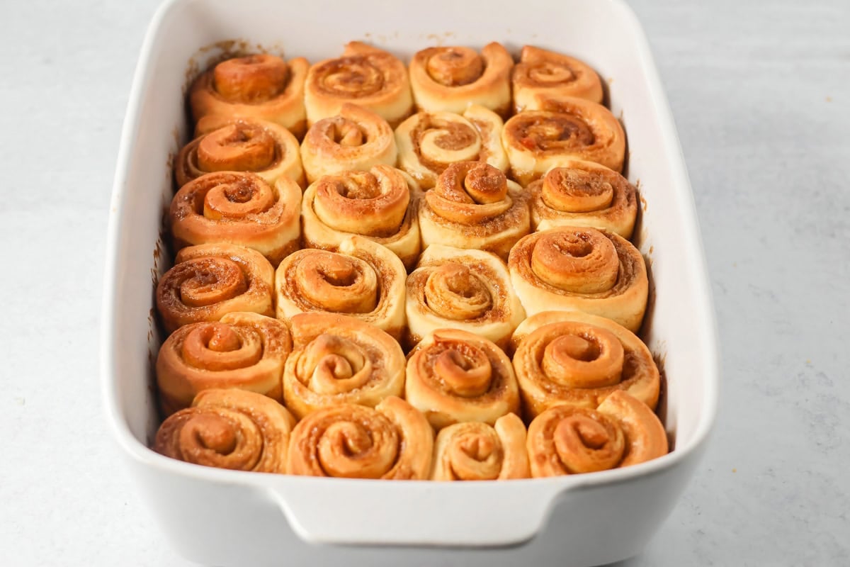 Baked mini cinnamon rolls in a white dish.