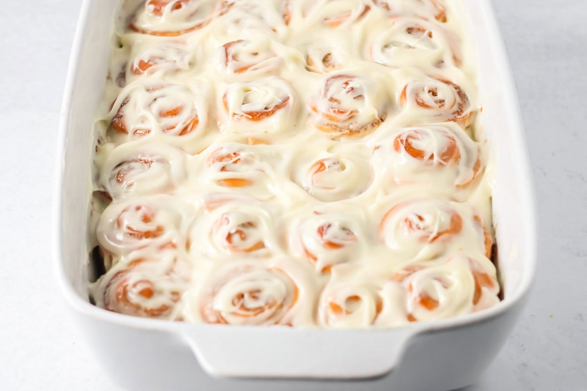 Frosted mini cinnamon rolls in a baking dish.