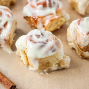 Frosted mini cinnamon rolls on brown paper.