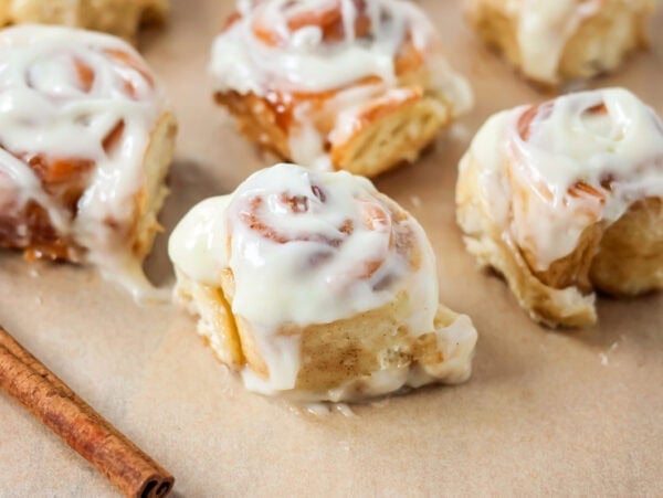 Frosted mini cinnamon rolls on brown paper.